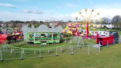 Small-town-fairground-Easter-holidays-attraction-funfair-rides-in-public-park-aerial-view