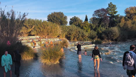 Wasser,-Das-Durch-Die-Thermalbecken-Herabstürzt,-Während-Menschen-Schwimmen-Und-Sich-Entspannen