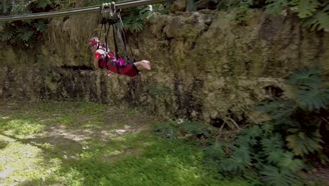 A-couple-of-Latin-American-travelers-having-fun-on-a-zipline-in-a-theme-park-skyline-surrounded-by-nature-in-Tulum-Mexico