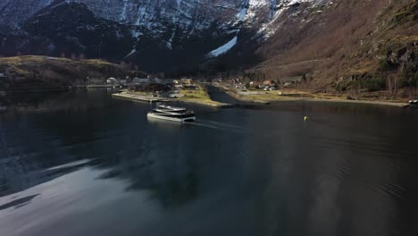 Electric-passenger-catamaran-Vision-of-the-fjords-is-approaching-Flam-harbor-in-beautiful-winter-sunlight---Aerial-Norway