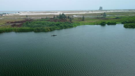 Victoria-Island-Lagos,-Nigeria---15-March-2022:-Drone-view-of-a-fisherman-on-a-fishing-boat-in-Kuramo-waters