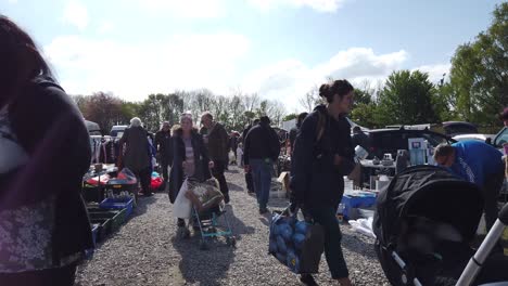 Bargain-hunters-browsing-busy-British-weekend-car-boot-garage-sale-for-unwanted-goods