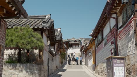 People-walking-around-in-Bukchon-Hanok-Village-in-spring-Seoul,-Korea---pullback-pov