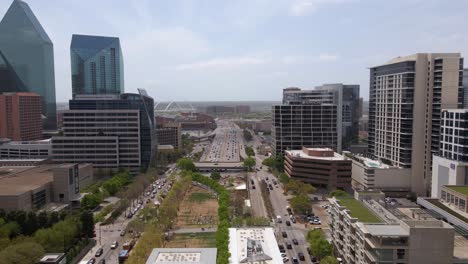 Vista-Aérea-Sobre-Los-Parques-De-La-Ciudad-Y-Hacia-La-Autopista,-En-El-Soleado-Dallas,-Texas,-Estados-Unidos