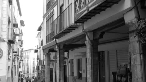 Panning-across-medieval-European-style-architecture-with-bow-windows-and-beautiful-balconies-in-black-and-white-Morella-old-town-center,-Spain