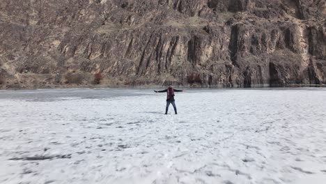 Adult-Male-Standing-On-Frozen-Khalti-Lake-With-Open-Arms