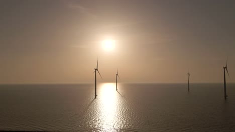 Flyover-Wind-turbines-seascape-and-Bright-sunlight-Reflection-on-water-surface