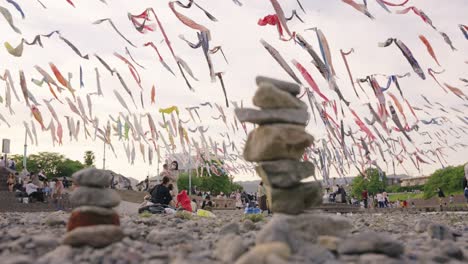 Rack-focus-reveal-from-pile-of-rocks-to-Japanese-families-and-Carp-Flags-on-children's-day