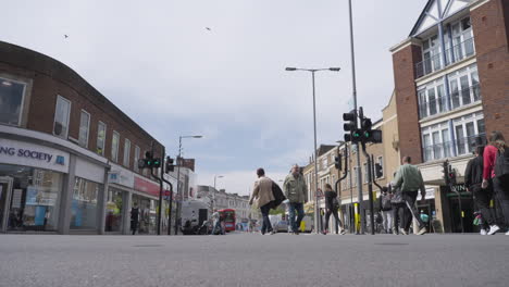 Beautiful-shopping-street-of-Kingston-Upon-Thames-filled-with-people,-low-angle-slow-motion-view