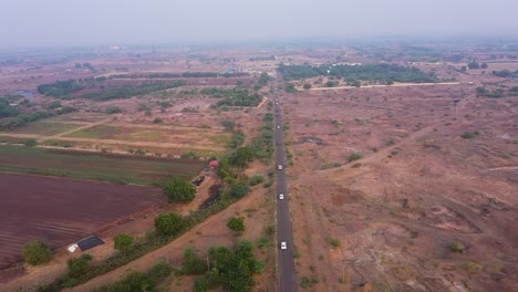 A-paved-road-can-be-seen-in-the-middle-of-a-village-where-many-white-cars-running-along-the-line