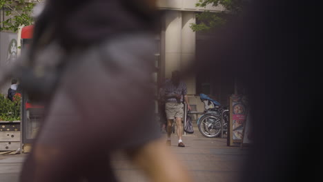 Elder-man-walking-in-streets-of-London,-distance-static-slow-motion-view