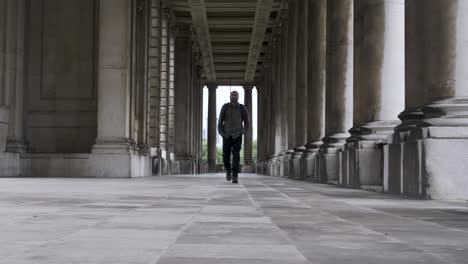 Turista-Masculino-Con-Mochila-A-Lo-Largo-De-La-Columnata-En-El-Royal-Navel-College-En-Greenwich-Hacia-La-Cámara