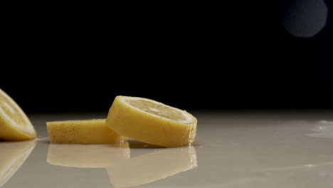 Sliced-lemon-falling-and-splashing-on-water-at-slow-motion