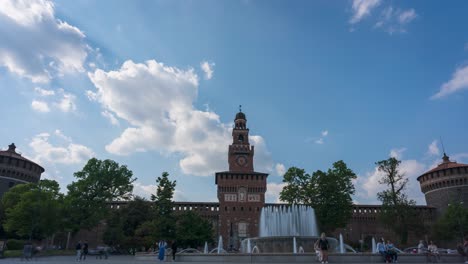 Lapso-De-Tiempo-Del-Castillo-Sforza,-Linda-Vista-De-La-Gran-Fuente-Y-Torre-Con-Fondo-De-Reloj-En-Un-Día-Soleado-Con-Nubes,-Milán,-Lombardía,-Italia