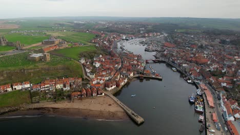 Aerial-ultra-wide-view-of-Whitby-harbor-in-Whitby,-North-Yorkshire,-England-with-river-and-buildings-in-the-background