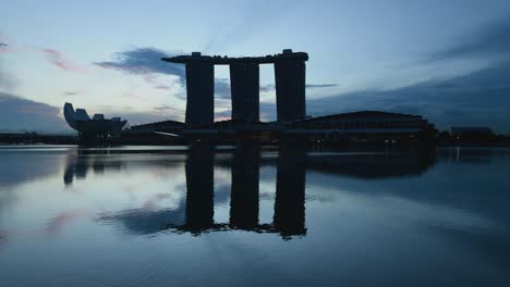 Wunderschöne-Ruhige-Landschaft-Der-Berühmten-Skyline-Von-Singapur-Mit-Dem-Mbs-Hotel-Und-Dem-Artscience-Museum,-Die-Sich-Im-Wasser-Spiegeln