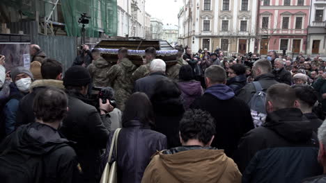 Mourners-follow-soldiers-carrying-the-coffin-of-a-fallen-comrade-into-the-entrance-of-the-Church-of-the-Most-Holy-Apostles-Peter-and-Paul