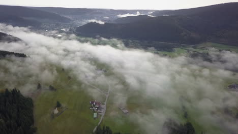 Flug-über-üppig-Grünes-Ackerland,-Das-Von-Niedrigen-Nebelwolken-Bedeckt-Ist