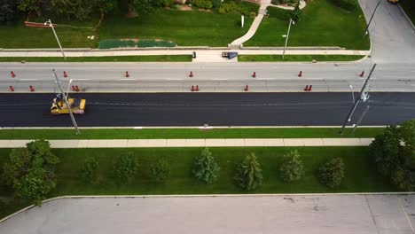Drone-view-of-roller-smoothing-out-new-asphalt