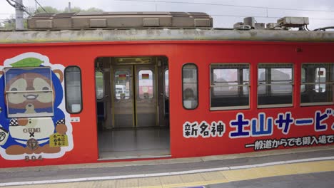 Vagón-Tanuki-Del-Ferrocarril-Omhi,-Con-Un-Anuncio-Turístico-Azuchi-En-El-Andén