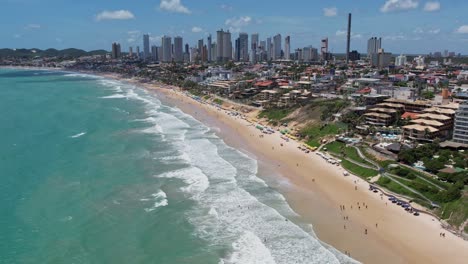 Panoramic-View-Of-Stunning-Beach-With-High-rise-Buildings-And-Tourists-In-Summer