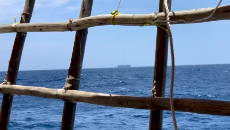 A-cargo-ship-far-away-in-the-middle-of-the-Arabian-sea-from-wooden-boat