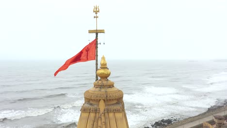 Aerial-backward-drone-view-of-trisula-in-the-top-of-the-mandir-in-Somnath-mandir-in-Gujrat