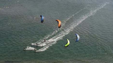 Four-kite-surfers-ride-together-in-calm-dutch-water-at-Tweede-Maasvlakte