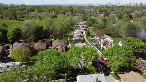 Drone-view-of-a-house-on-fire-with-a-fire-truck-on-site