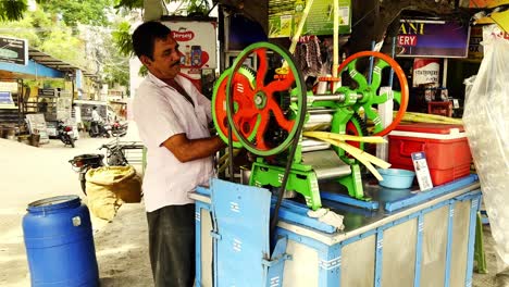 Man-uses-a-machine-to-crush-sugarcane-to-produce-sweet-and-sugary-juice-that-will-be-sold-in-the-market