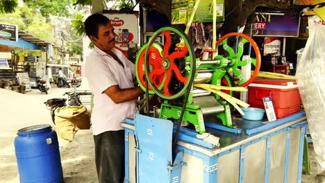 El-Hombre-Usa-Una-Máquina-Para-Triturar-La-Caña-De-Azúcar-Para-Producir-Jugo-Dulce-Y-Azucarado-Que-Se-Venderá-En-El-Mercado