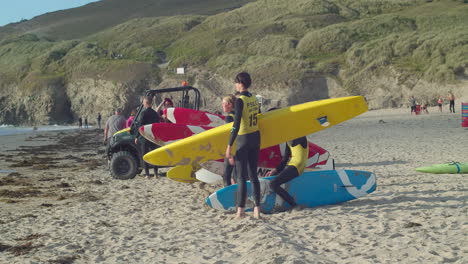 Niños-Pequeños-Practicando-Con-Sus-Tablas-De-Surf-Preparándose-Para-Correr-Hacia-El-Mar-En-Perranporth-En-Cornwall.