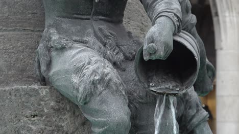 Primer-Plano-De-Agua-Que-Se-Vierte-De-Una-Cesta-Por-Una-De-Las-Estatuas-De-Bronce-En-La-Fuente-De-Pescado-En-Marienplatz-En-El-Corazón-De-Munich