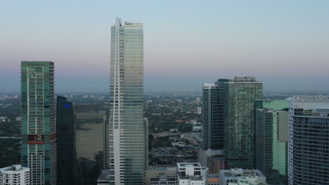 Late-evening-aerial-view-descending-away-from-Miami-skyscrapers-cityscape-horizon