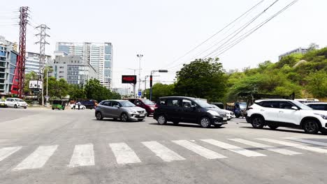 Viele-Fahrzeuge-überqueren-Die-Straße-Von-Rechts-Nach-Links,-Während-Zahlreiche-Fahrzeuge-Auf-Der-Gegenfahrbahn-Von-Links-Nach-Rechts-Fahren