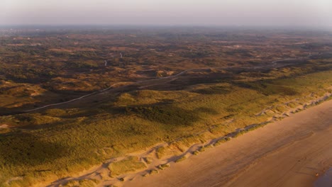Moving-drone-shot-of-the-beautiful-Dunes-of-Meijendel,-stretching-along-a-sandy-beach-of-South-Holland