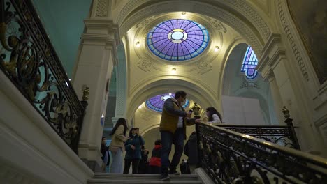 Santiago,-Chile---28.-Mai-2022:-Zeitlupe-Einer-Gruppe-Von-Menschen,-Die-Eine-Tour-Durch-Die-Nationalbibliothek-Von-Chile-Machen,-Beleuchtete-Kuppeln-Der-Struktur,-Erbetag