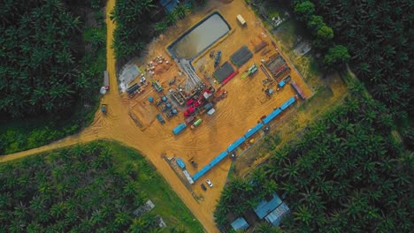 Cinematic-Onshore-Drilling-and-Workover-Rig-structure-and-Rig-equipment-for-oil-exploration-and-exploitation-in-the-middle-of-jungle-surrounded-by-palm-oil-trees-during-sunset-time
