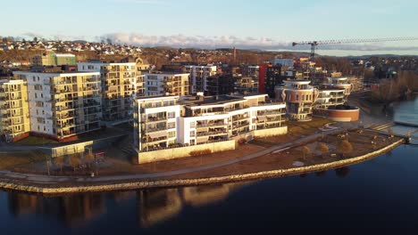 Vibrant-sunset-hitting-expensive-new-apartment-buildings-along-Hjellevannet-in-Skien-Norway---Seaside-aerial-looking-towards-buildings-in-Klosterhagen