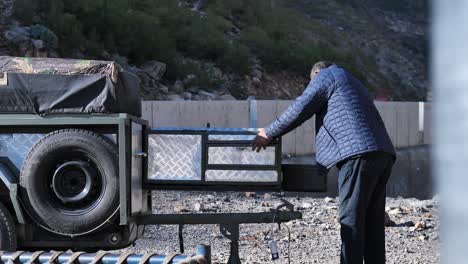 Adult-Male-Inspecting-Utility-Camping-Trailer.-Slow-Motion