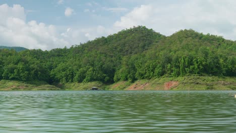 4K-Cinematic-landscape-nature-panoramic-footage-of-the-Mae-Kuang-Dam-Lake-at-Doi-Saket,-Northern-Thailand-on-a-sunny-day-while-sailing-on-a-moving-boat,-close-to-the-water