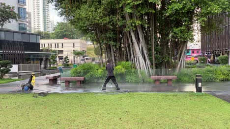 Workers-cleaning-pavement-with-high-pressure-water-jet