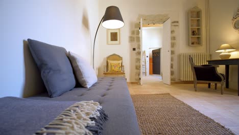 Rustic-Mediterranean-villa-resting-room-with-sofa-bench-couch-illuminated-by-spotlight-lamp,-Dolly-right-shot