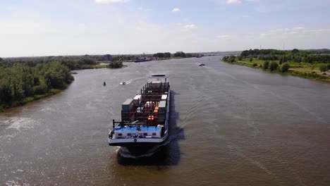 Aerial-Circle-Dolly-Around-Forward-Bow-Of-Missouri-Cargo-Ship-Travelling-Along-Oude-Maas