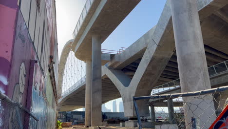 Establishing-Shot-of-Sixth-Street-Bridge-Next-to-Colorful-Graffiti-Wall-in-Daytime,-Looking-Up-From-Support-Beams