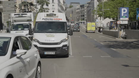 White-vehicles-driving-in-street-of-Marid,-slow-motion-view
