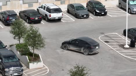 Sucio-Modelo-Tesla-Negro-Y-Conduce-A-Través-De-Un-Estacionamiento-Lleno-De-Vehículos-Tesla