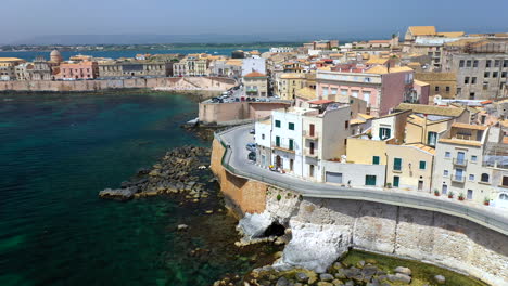 Rotating-drone-shot-of-Syracuse-coastline,-historic-city-on-the-Italian-island-of-Sicily