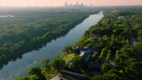 Rowing-crew-on-Town-Lake-with-Austin,-Texas-skyline-during-summer-sunrise-with-aerial-drone-in-4k
