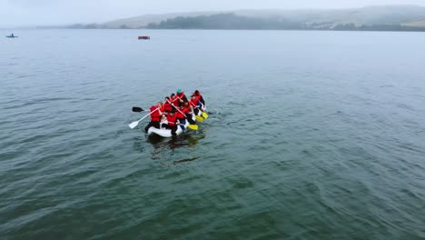 Beautiful-Planned-Shot-Of-Team-Wearing-Red-Life-Vests-Rafting-Towards-Stunning-Wide-Shore,-California